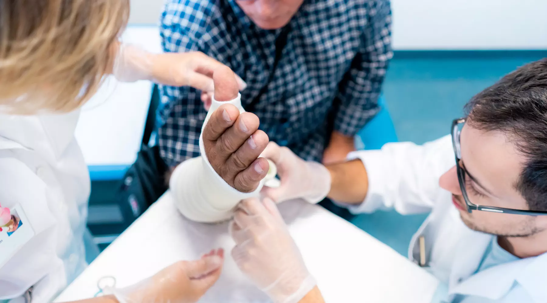 Un gypsothérapeute plâtre le bras d'un patient