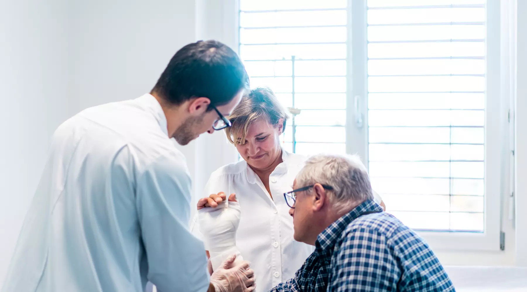 Un gypsothérapeute plâtre le bras d'un patient
