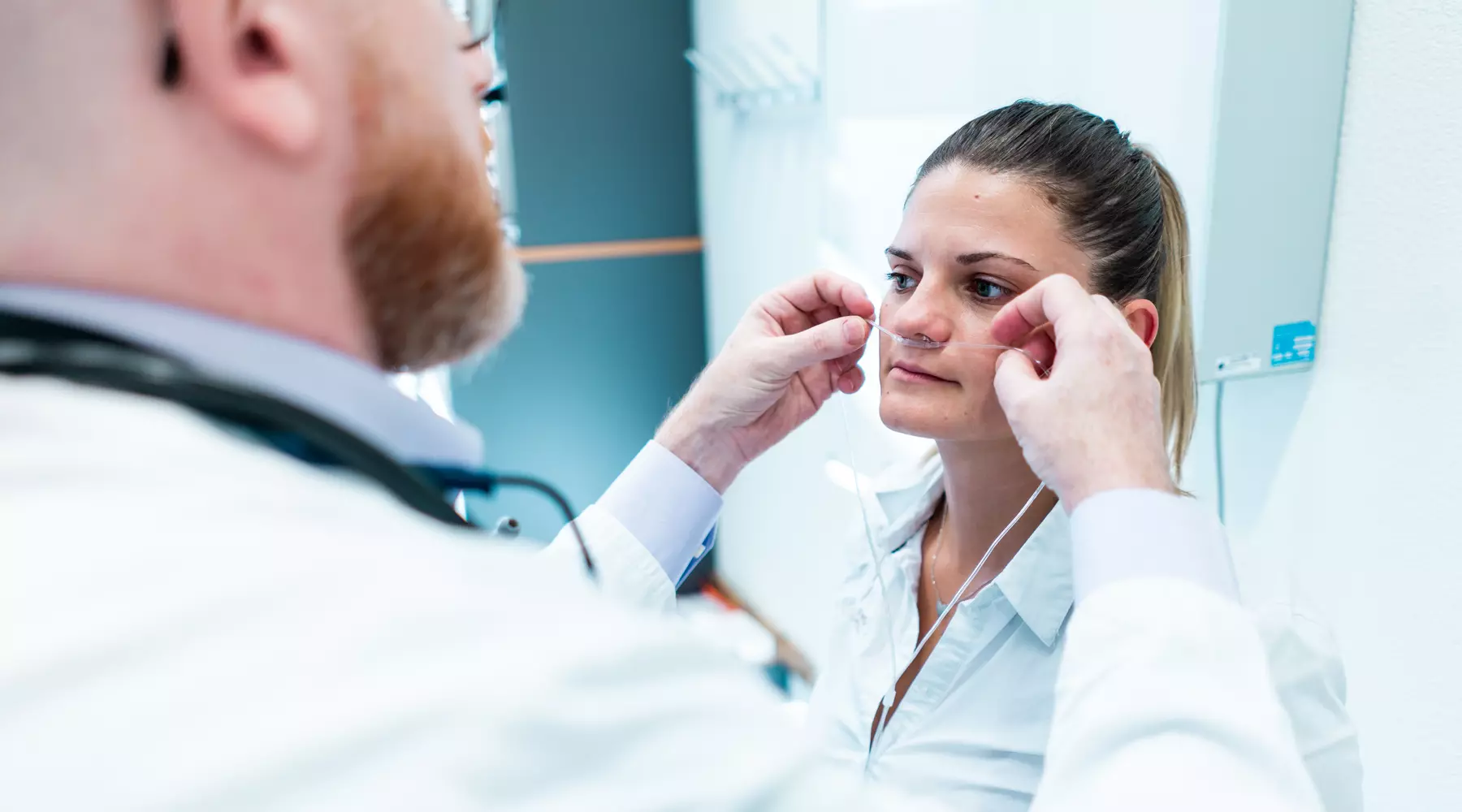 Un médecin ajuste un tube à oxygène sous le nez d'une patiente