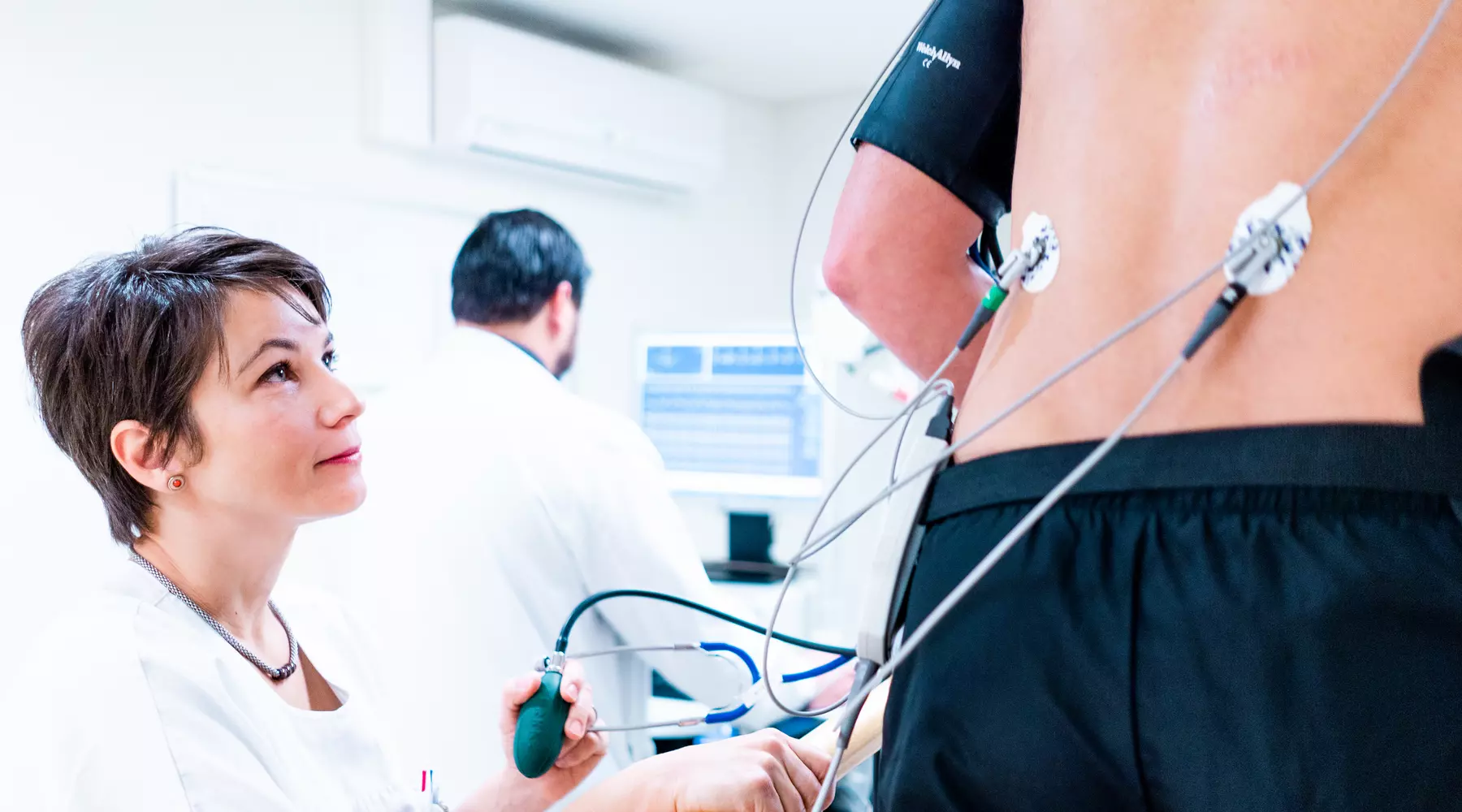 Test d'effort en cardiologie: une infirmière surveille un patient en train de courir sur un tapis roulant. 