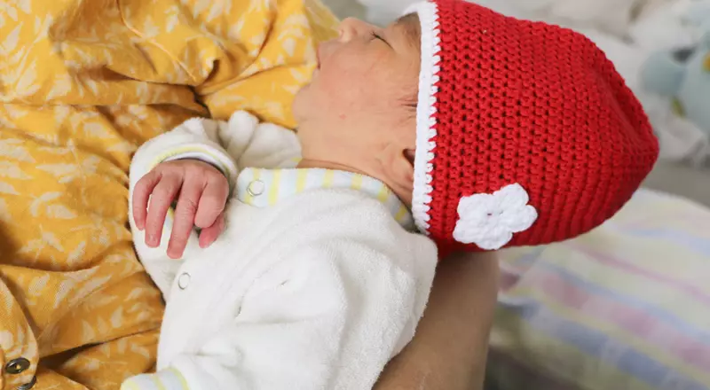 Un nouveau-né avec un bonnet rouge en tricot